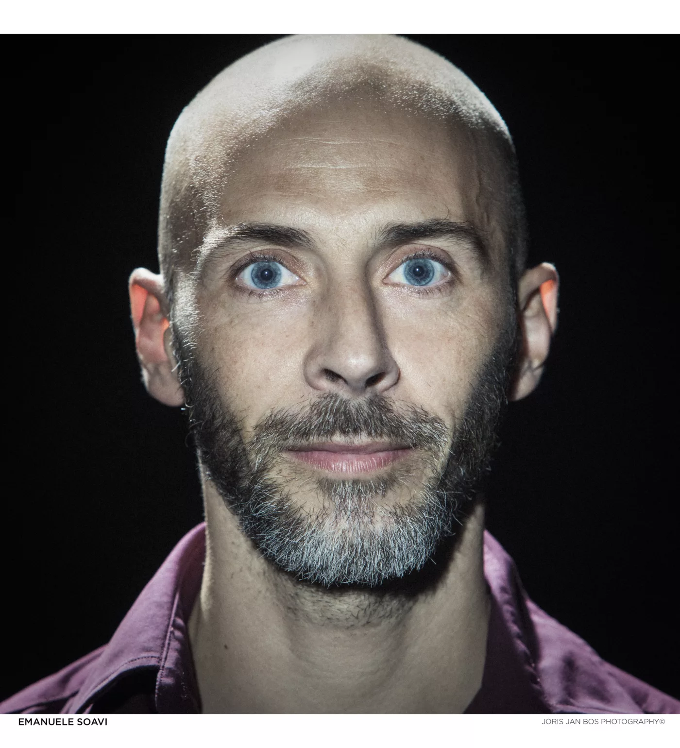 Porträt-Foto von Emanuele Soavi. Ein schlanker, weißer Mann mit rasiertem Kopf und Drei-Tage-Bart.